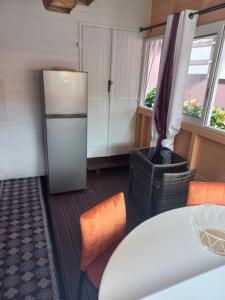 a kitchen with a refrigerator and some chairs at Joli appartement in Rivière-Pilote