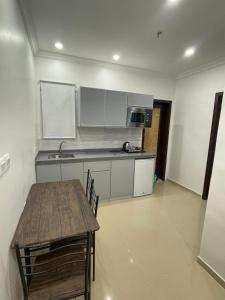 - une cuisine avec une table en bois et un comptoir dans l'établissement AL manzil ALmutmeez, à Djeddah