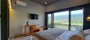 a bedroom with a bed and a balcony with a view at MAYURA BALI VILLA in Munduk
