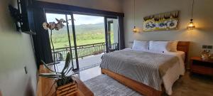 ein Schlafzimmer mit Bett und Balkon mit Aussicht in der Unterkunft MAYURA BALI VILLA in Munduk + 46 Fotos