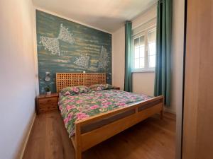 ein Schlafzimmer mit einem Bett und einem Wandgemälde in der Unterkunft Apartments Alić in Medulin