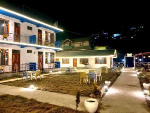 a house with chairs and a patio at night at Adinova in Kasol