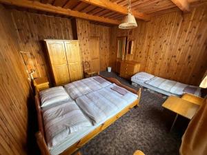 um quarto com 2 camas num chalé de madeira em Penzión Heľpa (do 25 hostí) em Heľpa