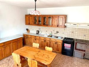 eine Küche mit Holzschränken und einem Holztisch in der Unterkunft Penzión Heľpa (do 25 hostí) in Heľpa