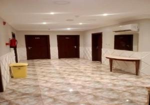 ein großes leeres Zimmer mit einem Tisch und zwei Türen in der Unterkunft حياة ريف للوحدات السكنية المفروشة in Dschidda