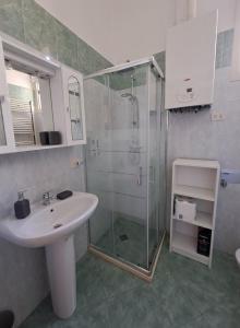 uma casa de banho com um lavatório e uma cabina de duche em vidro. em La Casa del Borgo em Lecce