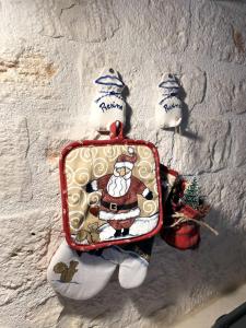 Dwie figurki Santa Clausa trzymające walizkę na ścianie. w obiekcie La Casetta di Lucia w Alberobello