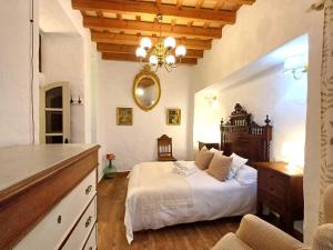 sypialnia z łóżkiem i żyrandolem w obiekcie La Guarida de Vejer Casa Rural w mieście Vejer de la Frontera