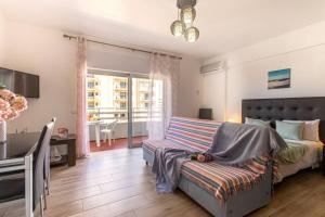 een woonkamer met een bed en een bank bij Casa dos Arcos BlueSky Studio by CC 804 in Portimão