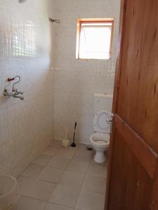 a bathroom with a toilet and a window at Magical Fharhana House in Malindi