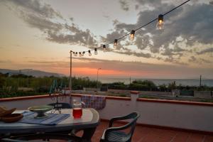 einen Tisch und Stühle auf einem Balkon mit Blick auf den Sonnenuntergang in der Unterkunft Appartamento Zia Lucia in Terme Vigliatore