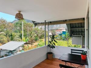 einen Balkon mit einer Bank und Bergblick in der Unterkunft Ao Luek Homie Homestay in Krabi