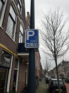 una señal de estacionamiento en un poste en una calle en Da Costa 12A en Leiden