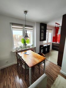 eine Küche mit einem Holztisch und Stühlen im Zimmer in der Unterkunft Apartament w centrum in Włodawa