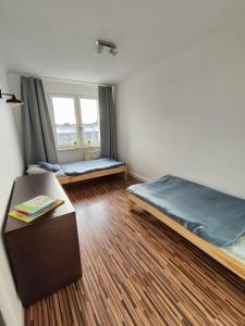 a room with two beds and a table in it at Apartament w centrum in Włodawa