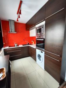 a kitchen with a washing machine and a microwave at Apartament w centrum in Włodawa