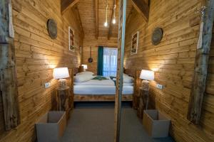 - une chambre avec un lit dans un mur en bois dans l'établissement ȘURA LU' PĂTRU, à Vulcan