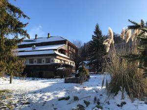 um grande edifício na neve com árvores cobertas de neve em Tor zum Kandertal beim Niesen/Mülenen em Mülenen 