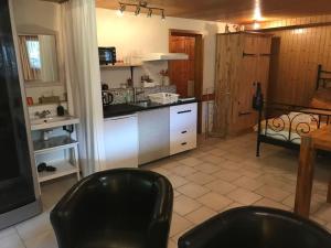 a kitchen with two black chairs in a room at Tor zum Kandertal beim Niesen/Mülenen in Mülenen 