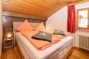 a bedroom with a bed with orange pillows at Ferienwohnungen Oberstdorf Schwartges in Oberstdorf