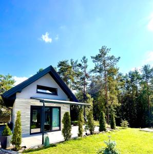 a small house in a field with trees at Świętokrzyskie Zacisze in Wołów