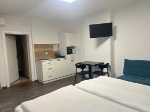 1 dormitorio con 2 camas, mesa y cocina en Apartment Zhang, en Graz