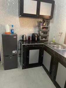 a small kitchen with a sink and a refrigerator at Appartement à Résidence Mamouja in Dakar