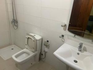 a bathroom with a toilet and a sink at Appartement à Résidence Mamouja in Dakar