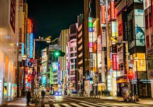 a busy city street at night with a green traffic light at APA Hotel Shinjuku Gyoemmae in Tokyo
