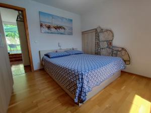 a bedroom with a bed with a blue comforter at Margarita in Baška