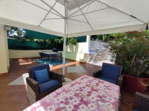 a patio with a table and chairs and an umbrella at Margarita in Baška