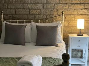 a bed with pillows and a lamp on a night stand at Peak District Stay Stylish for 2 Pass the Keys in New Mills