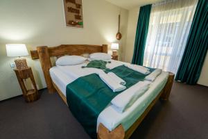 um quarto com uma cama com lençóis e almofadas verdes em ȘURA LU' PĂTRU em Vulcan