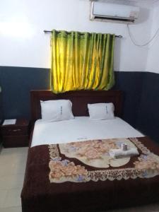 a bedroom with a bed with a yellow curtain at MARVELLOUS hotel in Lagos