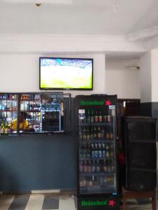 um bar com um frigorífico e uma televisão na parede em MARVELLOUS hotel em Lagos