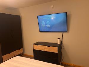 a bedroom with a flat screen tv on the wall at Cabañas Altos del Simpson in Coihaique