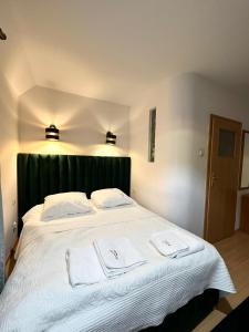 una camera da letto con un grande letto bianco con due asciugamani di Motel Za Miedzą a Bralin