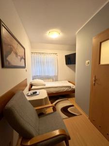 Habitación pequeña con silla y cama en Motel Za Miedzą, en Bralin