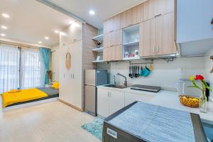 eine Küche mit weißen Schränken und einer gelben Arbeitsplatte in der Unterkunft Casa Par Grand Suites - Millennium Masteri, High-class and Central Location in Ho-Chi-Minh-Stadt