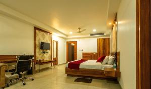 Hotel Parth Paradise في غازي آباد: غرفة نوم بسرير ومكتب وكرسي