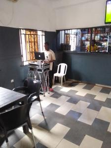 a man sitting at a table in a bar with a laptop at MARVELLOUS hotel in Lagos