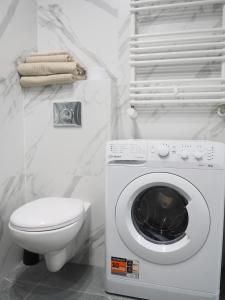 a bathroom with a washing machine and a toilet at SunApart A182 in Warsaw