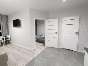 a white room with two doors and a bedroom at SunApart A182 in Warsaw