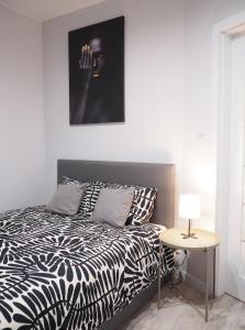 a bedroom with a black and white bed and a table at SunApart A182 in Warsaw