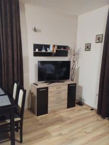 - un salon avec une télévision à écran plat dans un centre de divertissement en bois dans l'établissement Sozopol Harmani Beach Apartment 10, à Sozopol