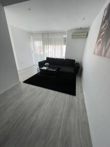 a living room with a black couch and a table at Marisah Residence #2 in Otopeni