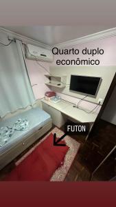 een kamer met een bureau en een computer. bij Quarto Deluxe em Foz piscina wifi estacionamento cozinha E AR in Foz do Iguaçu