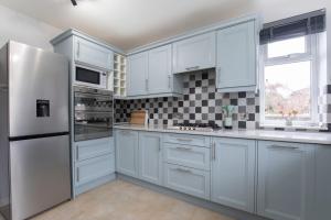 a kitchen with white cabinets and a white refrigerator at Central 1 Bedroom Apartment with Parking 