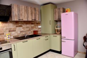 a kitchen with white cabinets and a pink refrigerator at Chez Mongauld in Verdun-sur-Meuse