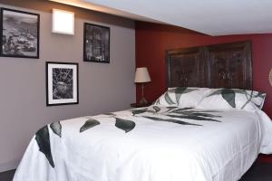 - une chambre avec un grand lit blanc dans l'établissement Chez Montgaud, à Verdun-sur-Meuse
